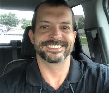 Male employee standing in front of box truck 