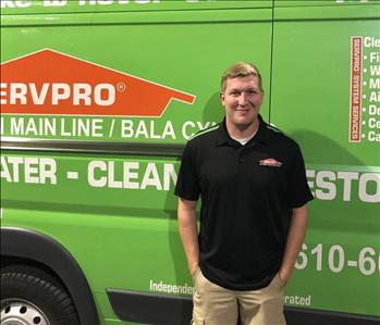 Male employee standing in front of box truck 