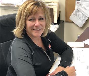 Female Employee with blonde hair looking at camera in her office 