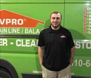 Male employee standing in front of box truck 